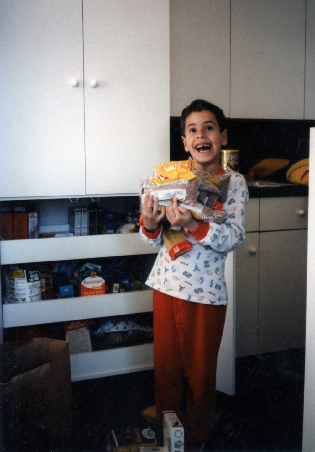 David as a kid holding an armful of packaged groceries